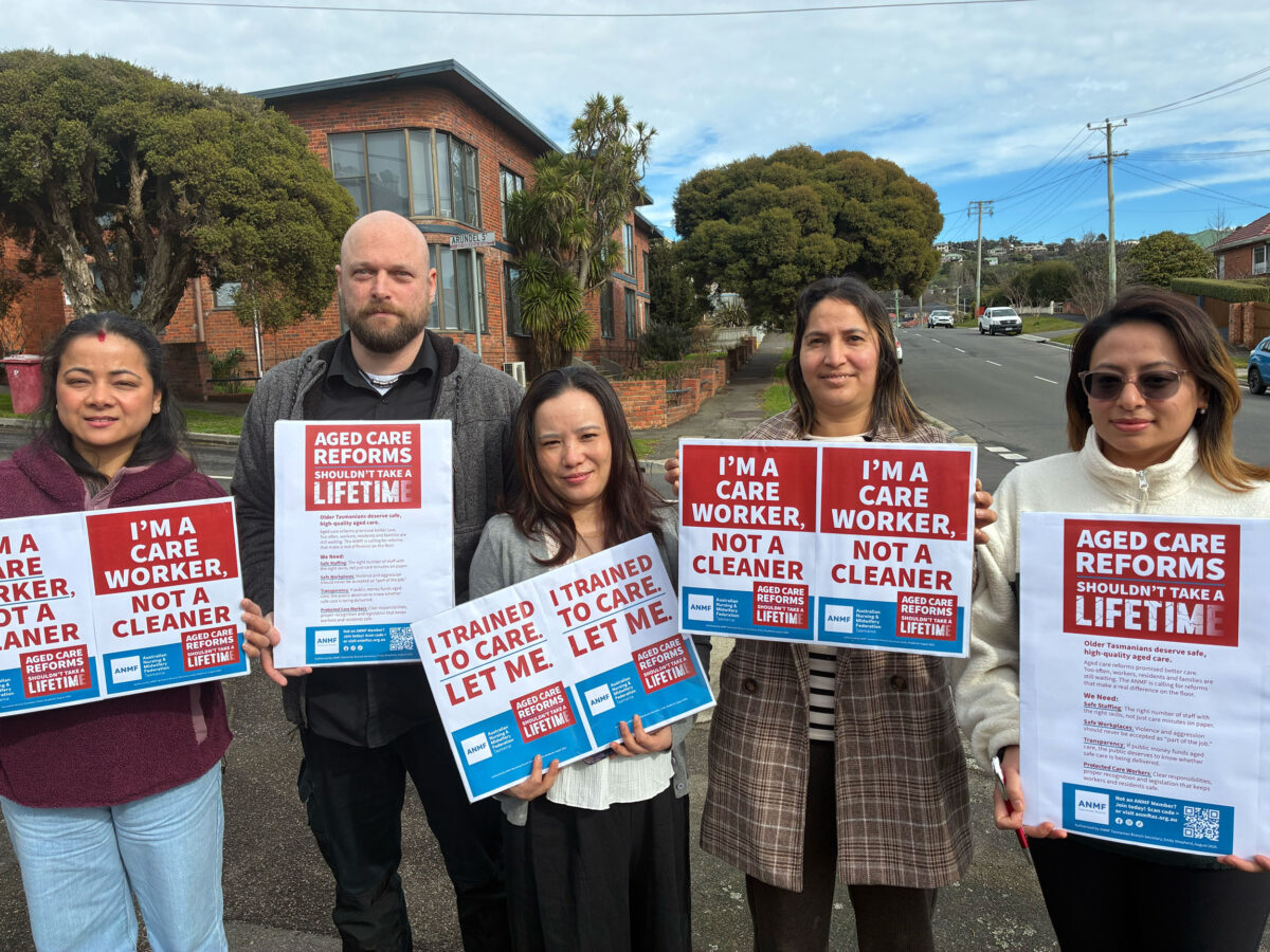 20260820-Aged-Care-Members 5 people stand holding signs on a street